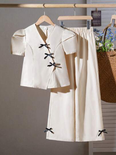 SHEIN Elladie kids مجموعة من قطعتين: ملابس علوية بأكمام منتفخة مع أزرار مائلة وهيم مطوي، مقترنة مع بنطلون ذو ساق مستقيمة وواسعة