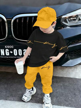 SHEIN Streecool Kids مجموعة ملابس للأولاد الصغار 2 قطعة، تي شيرت أسود بياقة مستديرة وبنطال أصفر، طباعة حرفية وجرافيكية عصرية، ملابس كاجوال مريحة مناسبة لجميع الفصول