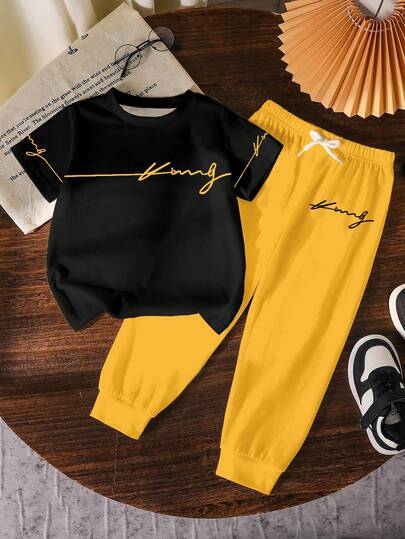 SHEIN Streecool Kids مجموعة ملابس للأولاد الصغار 2 قطعة، تي شيرت أسود بياقة مستديرة وبنطال أصفر، طباعة حرفية وجرافيكية عصرية، ملابس كاجوال مريحة مناسبة لجميع الفصول