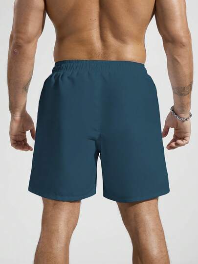 Manfinity Swimmode شورت شاطئ فضفاض بخصر رباط وجيوب مائلة مطبوع عليه أرقام وأحرف وأشجار النخيل الاستوائية، طراز الإجازة الصيفية للرجال