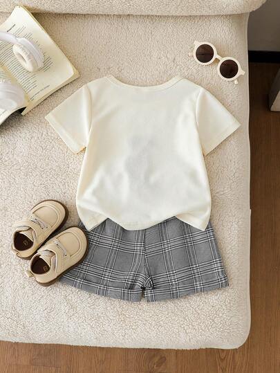SHEIN Playful Pals طقم قميص كاجوال قصير الأكمام مطبوع بشعار الدب الكرتوني الجميل وشورت أسود للأطفال الصغار، مناسب للارتداء اليومي، اللعب في الخارج، الأنشطة الأسرية، والرحلات العطلات