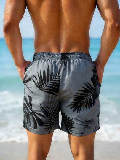 Manfinity Swimmode شورت شاطئ فضفاض مع جيوب مائلة وخصر بسحاب للرجال، طباعة استوائية لفصل الصيف