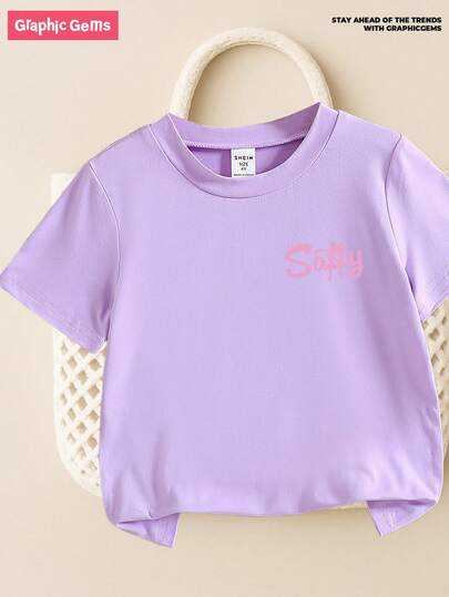 SHEIN GraphicGems تي شيرت كم قصير مطبوع بطبعة شاطئ للبنات الصغيرات، مثالي للارتداء اليومي، تي شيرت جرافيك لطيف باللون البنفسجي للبنات الصغيرات، لباس علوي كاجوال عصرية مناسبة لجميع المواسم، عطلة الصيف على الشاطئ